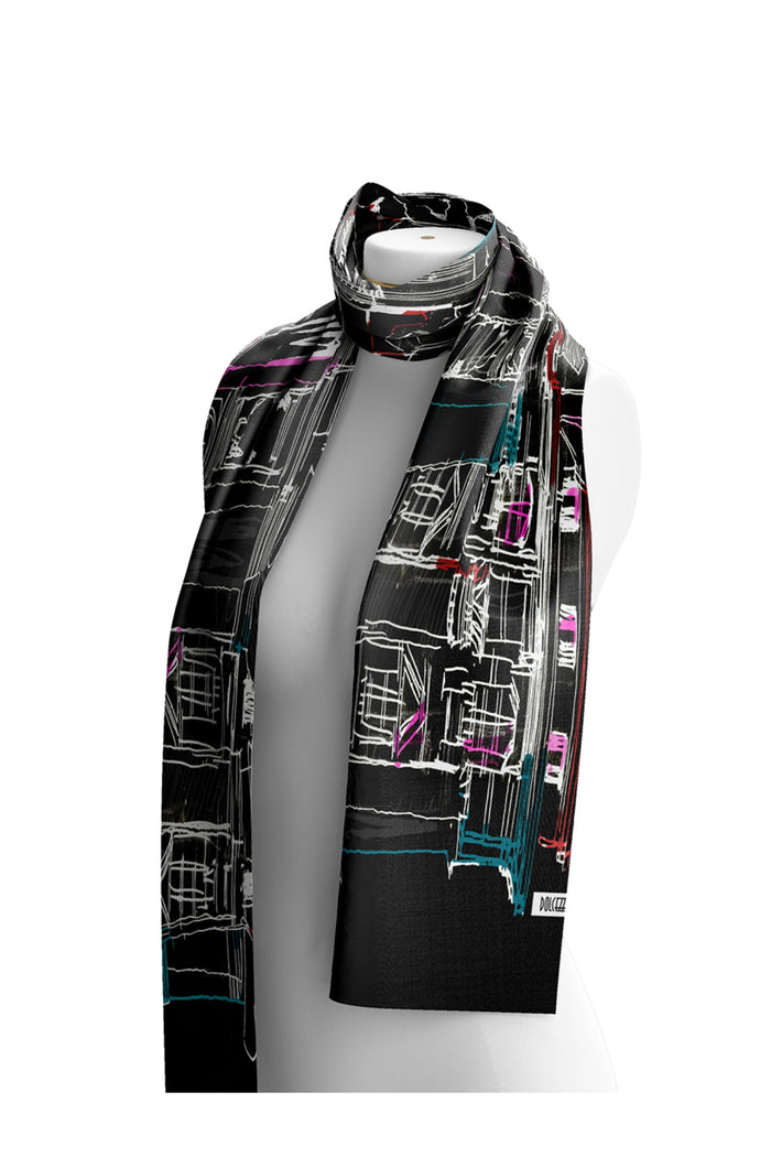Dotique Dolcezza 76904 assorted woven scarf featuring a black cityscape-inspired artistic print with white, teal, pink and red accents.