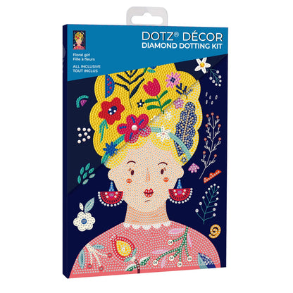 The Diamond Dotz Large Dotz Decor kit box shows an illustrated woman with yellow hair, red earrings, and a pink top, decorated with colorful flowers and floral patterns on a dark blue background.